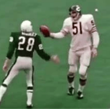 Chicago Bears linebacker Dick Butkus handing the football to an opponent after scoring a singleton.